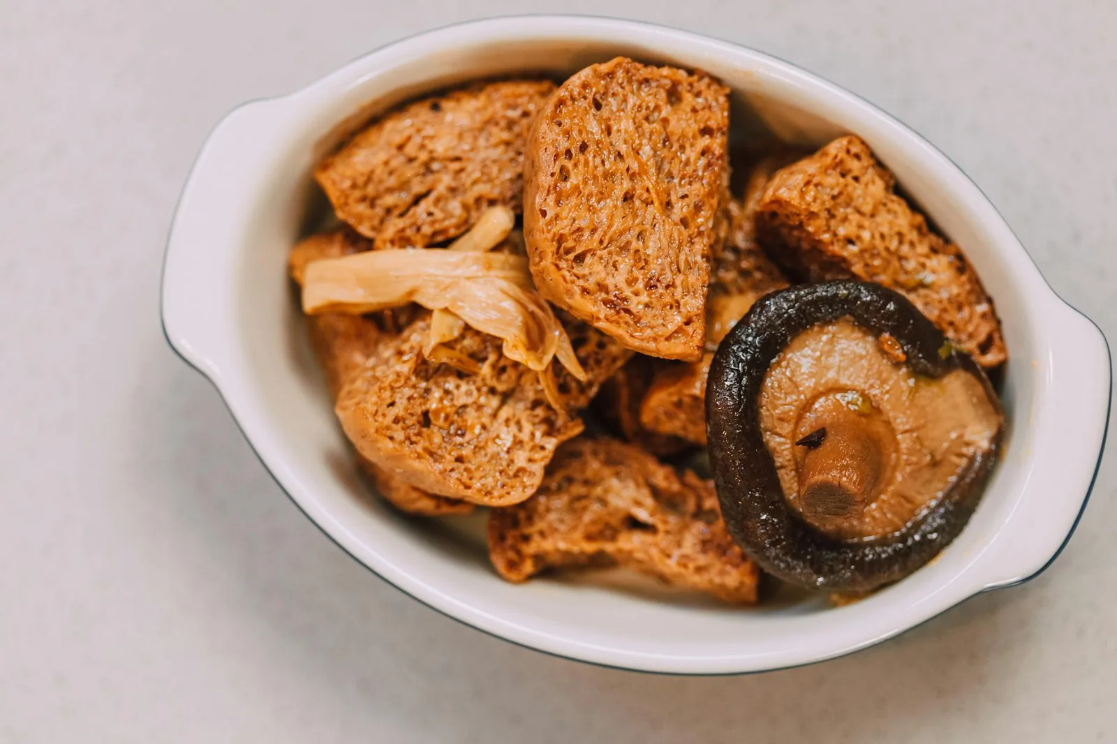 Kulhollinen sieniä ja sieniruokaa tarjoiltuna pöydällä